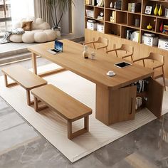 a wooden table with two benches and a laptop on it in front of a bookshelf