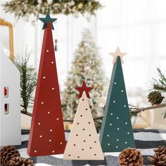 three wooden christmas trees sitting on top of a table