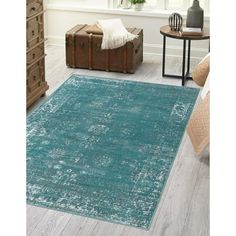 a living room with a blue rug on the floor next to a chair and table