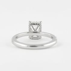 a white gold ring with a princess cut diamond