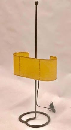 a lamp that is on top of a white surface with a yellow lampshade