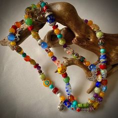 This cheerful long floral stretchy necklace features 86 glass beads, most of them millefiori, and some small gemstones like, turquoise, jade, agate, cat's eye, howlite, serpentine, 52 silver tone bead dividers and 8 charms, including a lady bug silver charm.  It is 28 inches long and weights  2.5oz. Millefiori  ( Italian) is a glasswork technique which produces distinctive decorative patterns on glassware.  The term millefiori is a combination of the Italian words "mille' (thousand) and "fiori" (flowers). The colorful beads can brighter your day and cheer you all day long for they radiate a positive and joyful feeling.  You can wear it as a necklace or you can convert it in a multi strand bracelet. This can make a great gift for mother, daughter, sister, bride's maid, Anniversary, birthday Bohemian Glass Necklaces With Large Beads, Bohemian Glass Necklace With Large Beads, Adjustable Multicolor Long Necklace For Gift, Bohemian Glass Necklaces With Round Beads, Hand-strung Glass Bohemian Beaded Necklaces, Hand-strung Bohemian Glass Beaded Necklaces, Glass Beaded Necklaces With 108 Beads As A Gift, Bohemian Glass Long Necklace Gift, Bohemian Glass Long Necklace For Gift