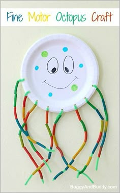 a paper plate with some colorful sticks attached to it and a face drawn on it