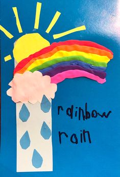 a child's hand made paper craft with a rainbow and rain