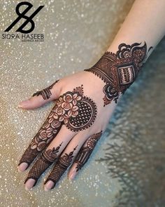 a woman's hand is decorated with hennap and intricate designs on it