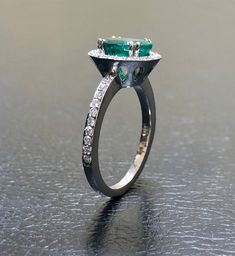 DeKara Designs Collection Our latest design! An elegant and lustrous Colombian Emerald surrounded by beautiful diamonds in a halo setting. Metal- 14K White Gold, .583. Stones- 1 Oval Colombian Emerald 1.25-1.40 Carats, 40 Round Diamonds, F-G color VS clarity, 0.30 carats. Latest of my creations. A beautiful Oval Colombian Emerald Halo Diamond Ring. The Emerald is a beautiful green and it is professionally prong set in between four double prongs. There are ten pave set round diamonds on each side Luxury Emerald Ring With Halo, Modern Emerald Ring Vvs Clarity For Wedding, Modern Emerald Ring With Vvs Clarity For Wedding, Luxury Emerald Ring With Halo Design For Wedding, Dazzling Oval Emerald Ring In Platinum, Luxury Emerald Rings With Halo Detail, Anniversary Emerald Ring With Halo Diamond Design, Luxury Emerald Ring With Halo And Round Cut, Luxury Round Emerald Ring With Halo