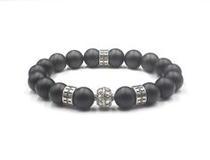 This bracelet features 10mm matte black onyx beads accented with four sterling silver Bali beads. We use silicon stretch cord for superior strength. Choose your wrist size from the drop down menu. We will make your bracelet to fit. Your bracelets comes in a bracelet gift box. Check out our Bracelets for Men: https://www.etsy.com/shop/KartiniStudio?section_id=16866423&ref=shopsection_leftnav_2 Check out our men's Deluxe Bracelets: https://www.etsy.com/shop/KartiniStudio?ref=hdr_shop_menu& Elegant Black Beaded Bracelets With 8mm Beads, Black Wristband With 8mm Beads, Classic Black Bracelets With 8mm Beads, Classic Black Onyx Bracelets, Classic Black Onyx Bracelet, Mens Bracelet Black, Bracelet Gift Box, Howlite Bracelet, Obsidian Bracelet