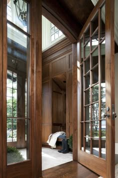 an open door leading into a room with wood paneling and glass doors on both sides