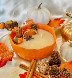 an orange bowl filled with candles surrounded by autumn decorations