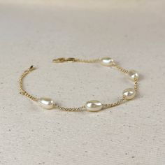 Indulge in the timeless beauty and sophistication of our 18k Gold Filled Spaced Baroque Pearl Bracelet. The perfect blend of elegance and delicacy, this classic piece exudes a luxurious charm that will elevate any outfit. Add a touch of opulence to your wardrobe and captivate with every turn of your wrist. * Metal: 18k Gold Filled * Width: 10mm Simulated Baroque Pearl  Beads * Size:  6.5 + 1 inch adjustment. * Hypoallergenic * Water-resistant * Handcrafted in Brazil Hand Chain Bracelet, 18k Gold Chain, Jewelry Lookbook, Emerald Jewelry, Anklet Jewelry, Earrings Collection, Baroque Pearls, Chain Link Bracelet, Cute Jewelry