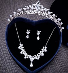 a necklace and earring set in a heart shaped box on top of a table