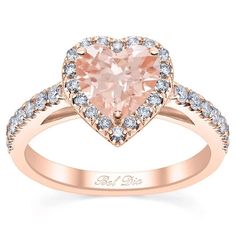 a heart shaped pink diamond ring with white diamonds on the band and an open shank