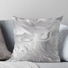 a gray and white pillow sitting on top of a couch