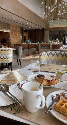 a table topped with plates and cups filled with food