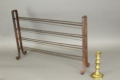 an old metal rack with two candles and a candle holder next to it on a white background