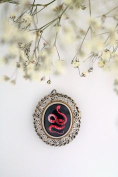 This pendant with hand painted miniature depicts one of the most fascinating and dangerous creatures on earth: the coral snake. Although he can kill in a few minutes, his appearance is decidedly colorful and elegant, so as to seem a sinuous jewel himself. The snake is an ancient symbol that can have both negative and positive meaning. Creature of evil and original sin in Genesis, it can also be synonymous with wisdom and infinity. The locket in which the miniature is inserted is antique in 800 s Snake-shaped Engraved Jewelry Gift, Unique Engraved Snake Jewelry, Engraved Snake-shaped Jewelry Gift, Vintage Snake-shaped Jewelry Gift, Vintage Snake Jewelry For Gifts, Vintage Silver Snake Jewelry, Red Snake-shaped Jewelry For Gifts, Antique Hand Painted Jewelry For Gifts, Antique Hand Painted Jewelry Gift