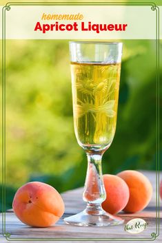 a glass filled with liquid next to peaches