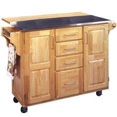 a wooden kitchen island with black top and drawers on casteors, in front of a white background