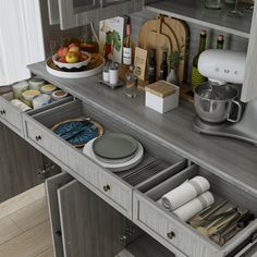 an open drawer in a kitchen next to a counter with dishes and utensils