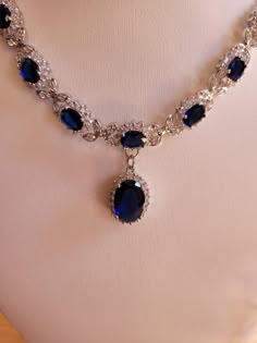 Created sapphire and diamond necklace and earring set.  Sapphire chain is 18 inches non adjustable and comes with a one inch extender.  Sapphires are 3mm oval and center stone is 7mm oval.  Diamond accents.  Earrings are two inches with a 1.75 inch drop.  7mm oval center stone.  Set in stamped 925 silver. Sapphire Necklace And Earring Set, Blue Sapphire Necklace Gold, Oval Jewelry With 17 Jewels For Evening, Oval Cubic Zirconia Necklaces For Formal Occasions, Sapphire And Diamond Necklace, Formal Sapphire Teardrop Jewelry, Exquisite Oval Jewelry For Evening, Elegant Sapphire Necklace With Hand-set Details, Fine Jewelry Oval Evening Jewelry