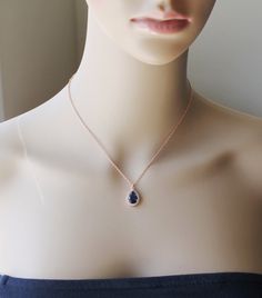 a mannequin wearing a necklace with a blue stone