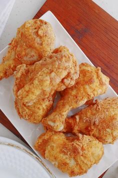 some fried food on a white plate next to a fork