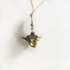 a gold and black necklace with a cow's head hanging from the front, on a white background