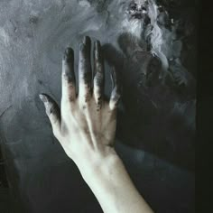 a person's hand with black and white paint on it