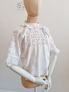 This Romanian blouse features geometrical cut-out embroidery and an adorable Peter Pan collar with white floral embroidery. The sleeves have the same geometrical cut out embroidery that is featured on the front of the blouse as well, that are a fine example of handwork.  MATERIAL: Linen CONDITION: Really good vintage condition.  Measurements: (taken flat / lying down) Total length:  55 cm Bust size (underarm to underarm): 45 cm Armhole: 20 cm Waist: 48 cm Shoulder width: 39 cm Sleeve length: 26 Luxury Embroidered Linen Blouse, Luxury Linen Embroidered Blouse, White Embroidered Top With Collar, White Peter Pan Collar Blouse For Summer, White Blouse With Peter Pan Collar For Summer, White Tops With Lace Trim And Peter Pan Collar, White Blouse With Peter Pan Collar For Spring, White Shirt With Floral Embroidery Collar, Summer Cutwork Cotton Blouse