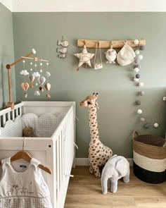 a baby's room with a giraffe, elephant and crib in it