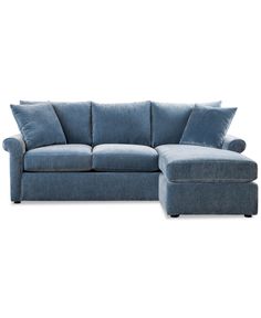 a blue sectional couch with pillows on it's back and the seat upholstered