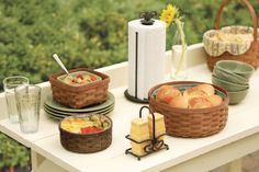 a table topped with plates and baskets filled with food on top of a white table