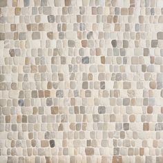 a white and brown tile wall with small squares on it's sides, all in different colors