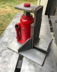 a red fire extinguisher sitting on top of a wooden table in front of a house