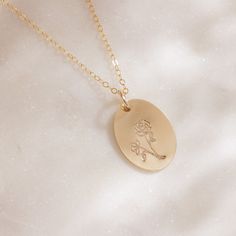 Delicate with a touch of whimsy, this hand-stamped pendant necklace features a flower design that represents your birth month. From the petite snowdrops of January to the classic holly of December, every month is represented (and some with two), making the Birth Month Necklace a great gift for moms, grandparents and friends, or any nature lover in your life. We love the subtle femininity it offers on its own, but because the oval pendant is suspended from a dainty gold chain that falls just belo Everyday Engraved Flower Pendant Jewelry, Personalized Flower Jewelry For Everyday, Engraved Flower Pendant Jewelry For Everyday, Dainty Flower-shaped Engraved Charm Necklaces, Dainty Engraved Flower Charm Necklaces, Dainty Engraved Flower Charm Necklace, Delicate Engraved Charm Necklaces For Mother's Day, Engraved Flower Pendant Necklace For Mom, Engraved Flower Pendant Charm Necklace For Mom