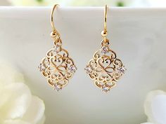 These lovely filigree earrings, have a beautiful 24k champagne gold finish. Tiny, clear zircon gemstones, embellish the ornate design. They are lightweight, making them comfortable to wear. Product details: - 18k gold plated ear wires; Lead and nickel free - 24k champagne gold filigree charm with clear zircon gemstones - Handmade, with lots of love and care! * Length:      .9 inches * Width:       .5 inches ❤ You can click here to see more unique jewelry from Flutterbird: https://www.etsy.com/shop/FlutterbirdCo My goal is to provide every customer with exceptional service. Please message me if you have any questions. Thank you for supporting my small business!  Please visit my F.A.Q. and shop policy sections for additional info. Elegant Diamond Crystal Earrings For Gift, Elegant Crystal Earrings Designed As A Gift, Elegant Yellow Gold Crystal Earrings For Anniversary, Elegant Gold Diamond Earrings As Gift, Elegant Rose Gold Filigree Earrings, Elegant Gold Bridal Earrings With Diamonds, Elegant Gold Diamond Bridal Earrings, Gold Delicate Crystal Earrings For Party, Delicate Gold Crystal Earrings For Party