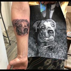 a person with a tattoo on their arm and a photo of a dog in the background