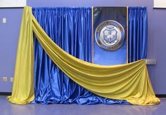 a blue and yellow stage set up with drapes