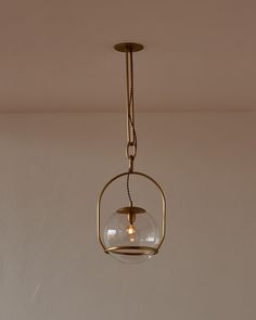 a light fixture hanging from the ceiling with a clear glass ball in front of it