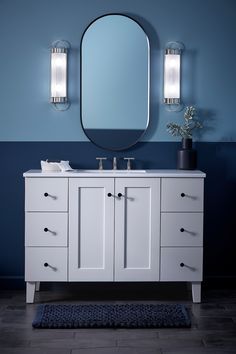 a bathroom vanity with two mirrors above it and a rug on the floor next to it