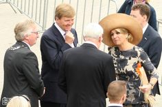 a woman in a large hat is surrounded by other men and women at an event