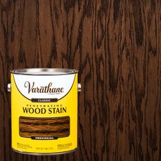 a can of wood stain sitting on top of a wooden floor next to a wall