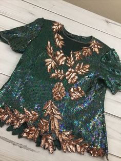 Women's Razzle Dazzle Green/Gold Sequin & Silk Short Sleeve Blouse *No size tag*. See measurements photos. Item is in used condition. Shipped with USPS Shipping. Green Tops For Evening Party Season, Green Sequin Tops For Fall, Green Sequined Party Blouse, Festive Green Sequined Tops, Festive Green Sequin Tops, Green Sequined Short Sleeve Tops, Green Sequined Blouse For Evening, Fall Sequined Short Sleeve Blouse, Fall Sequin Short Sleeve Blouse