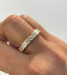 a woman's hand with a diamond ring on top of her finger, showing the band