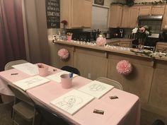 the table is set for two with pink napkins and cups on it, along with other decorations