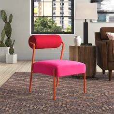 a pink chair sitting on top of a rug in a living room