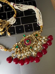 Delving deep into our rich culture of traditional Ahmedabadi Pachi / Pacchi Kundan Gold Finish Dainty Necklace Set. Flaunt in this classic jewelry lavishly strung with deep green and red beads with cluster of pearls & drops. This necklace is drawstring adjustable. Perfect wedding wear and Rich colors to match any Indian Traditional Attire.   WHAT GOES IN  👉🏻Pachi Kundan high quality stones, pearl and bead drops. 👉🏻Gold Plated Brass based metal. 👉🏻Send us an email if you need help! ✅ Contact Us: +1 (732) 325-2222 Luxury Temple Jewelry Kundan Necklace For Diwali, Luxury Kundan Necklace For Diwali Ceremonial, Luxury Meenakari Chandbalis For Diwali, Luxury Temple Jewelry For Diwali, Traditional Red Kundan Necklace For Ceremonial Use, Festive Traditional Kundan Necklace With Detachable Pendant, Traditional Red Kundan Beaded Necklaces, Traditional Red Gold-plated Kundan Necklace, Elegant Red Kundan Gold-plated Necklace