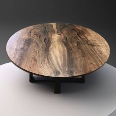 a wooden table sitting on top of a white round table clothed with black lines