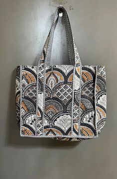 a handbag hanging on the wall with an orange and white pattern in it's center