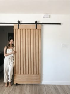 a woman standing in front of a sliding door with her hand on the side of it